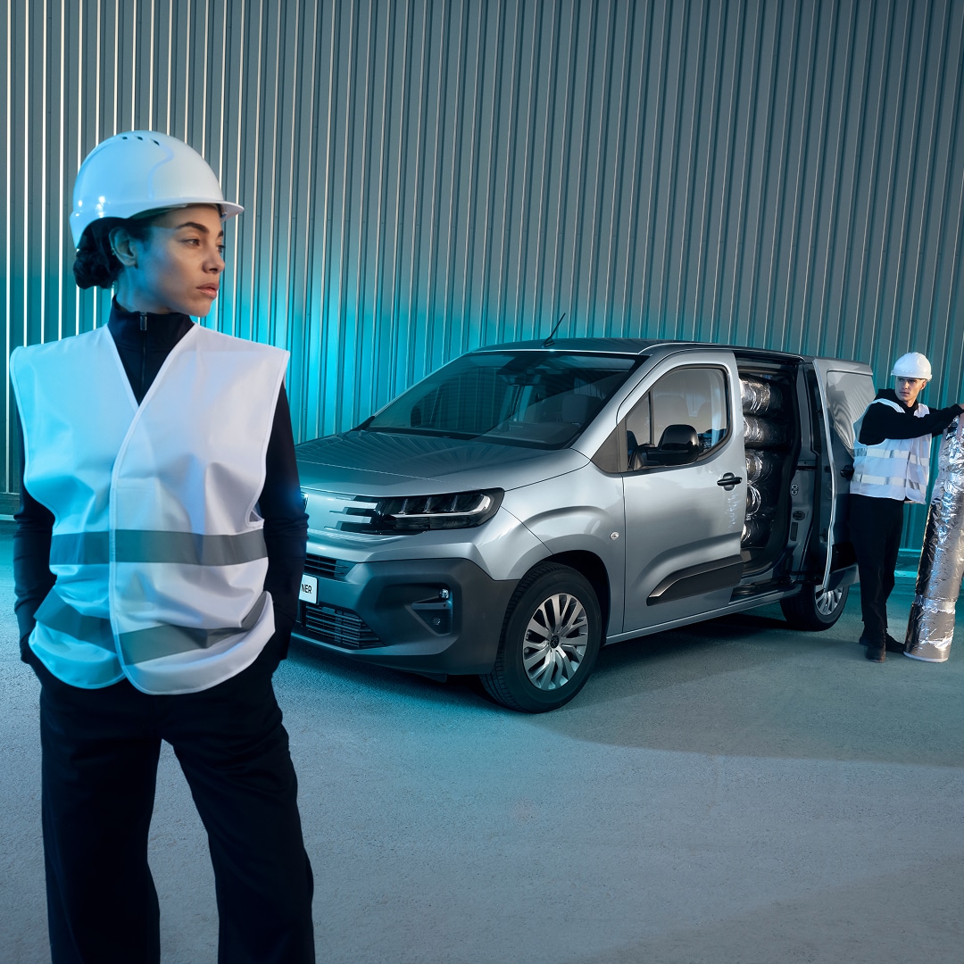 Mulher em pé em frente um PEUGEOT Partner