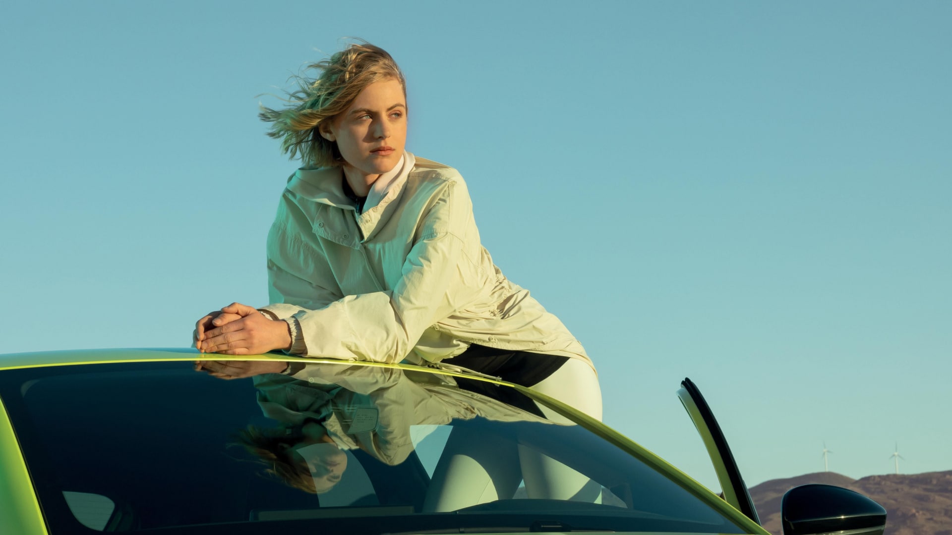 Mulher encostada a um PEUGEOT 208
